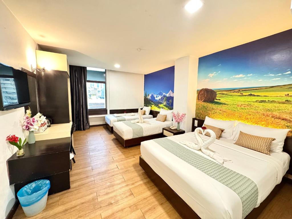 a hotel room with two beds and a couch at Swiss Hotel at City Centre in Kuala Lumpur