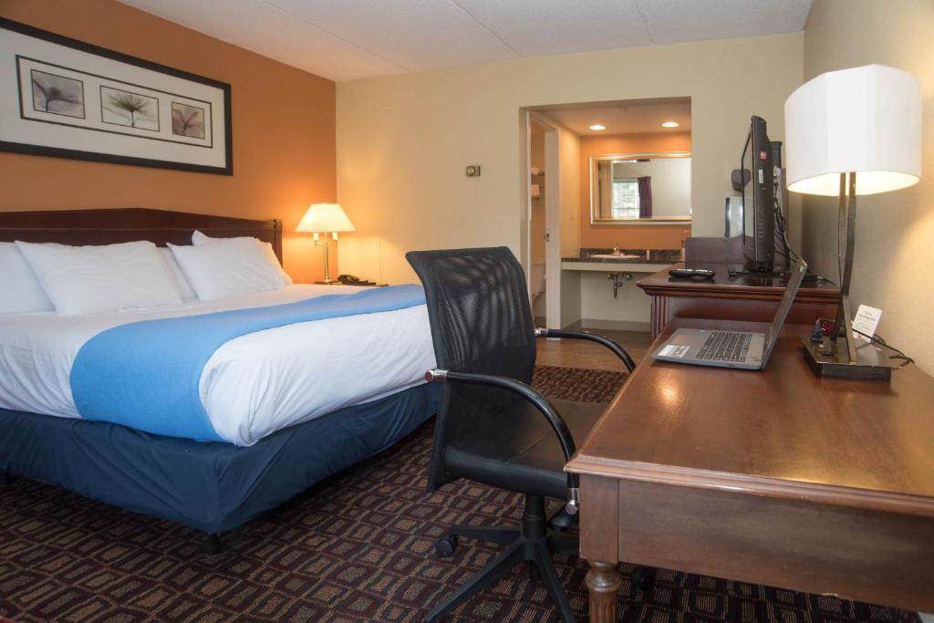 
a hotel room with a bed and a desk at Colonnade Inn in Lyndonville
