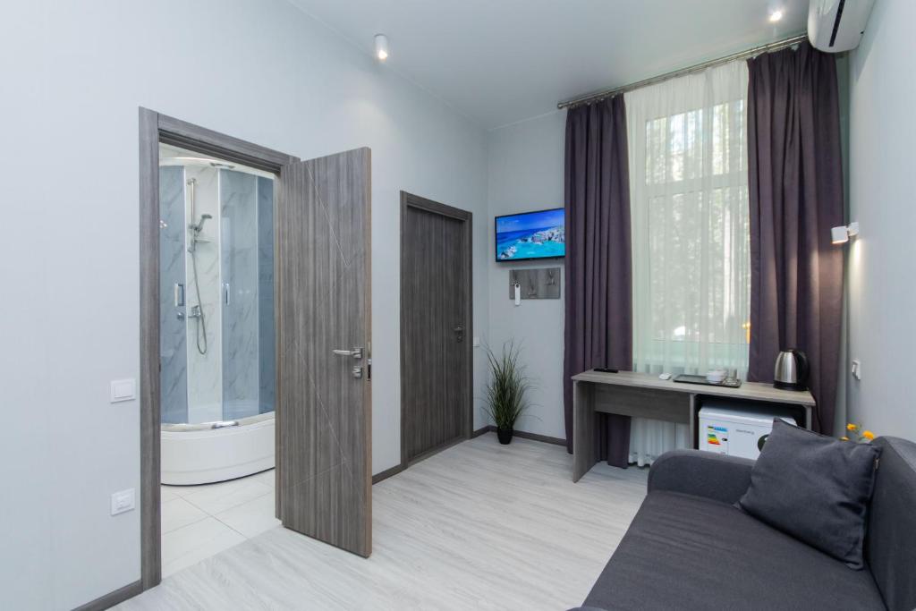 a living room with a couch and a bath tub at Seven Apart Hotel in Vyshneve