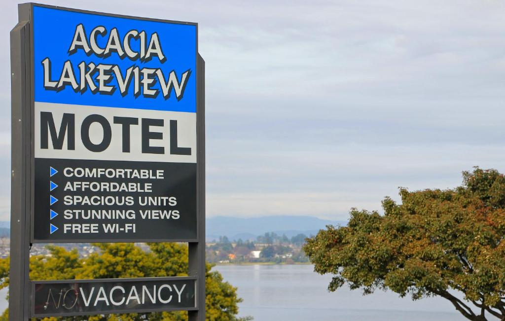 a sign for a motel with a view of the water at Acacia Lake View Motel in Taupo