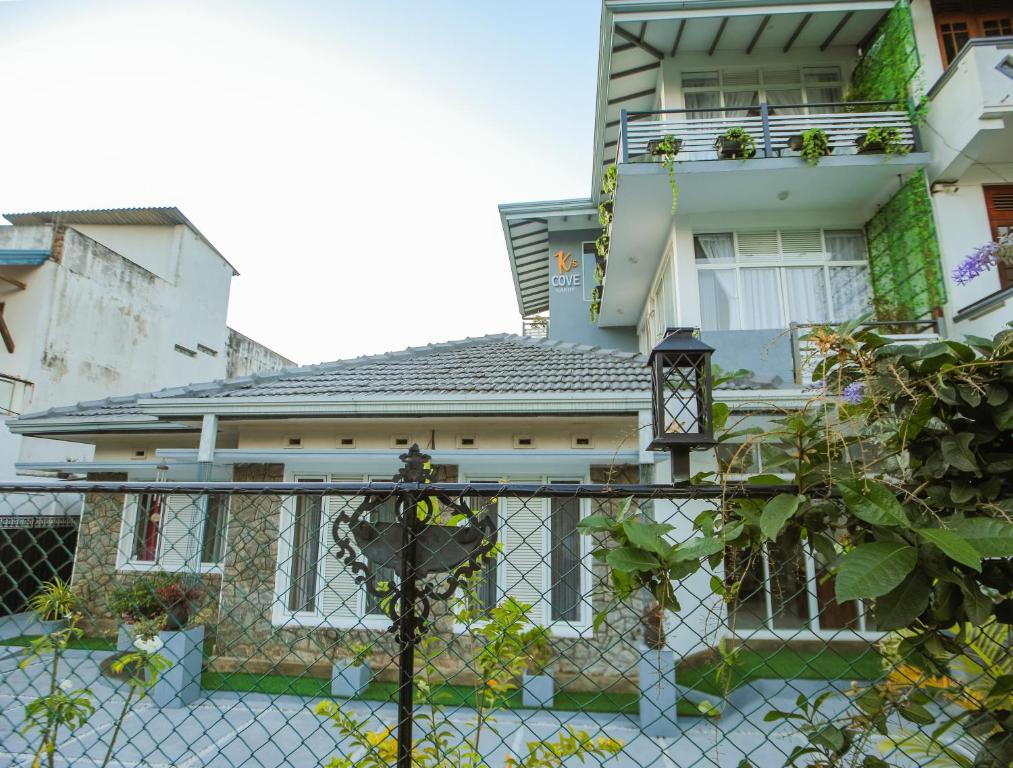 a house with a fence in front of it at K's Cove in Kandy