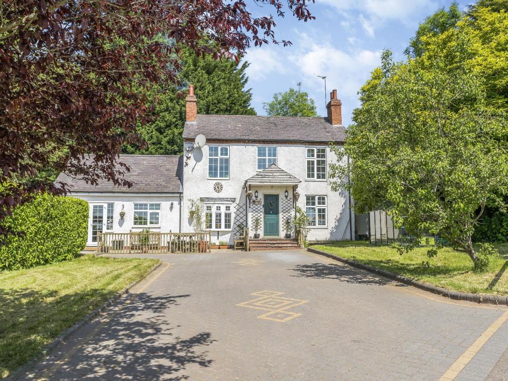 a white house with a driveway in front of it at Oakdale Lodge in Hopwood