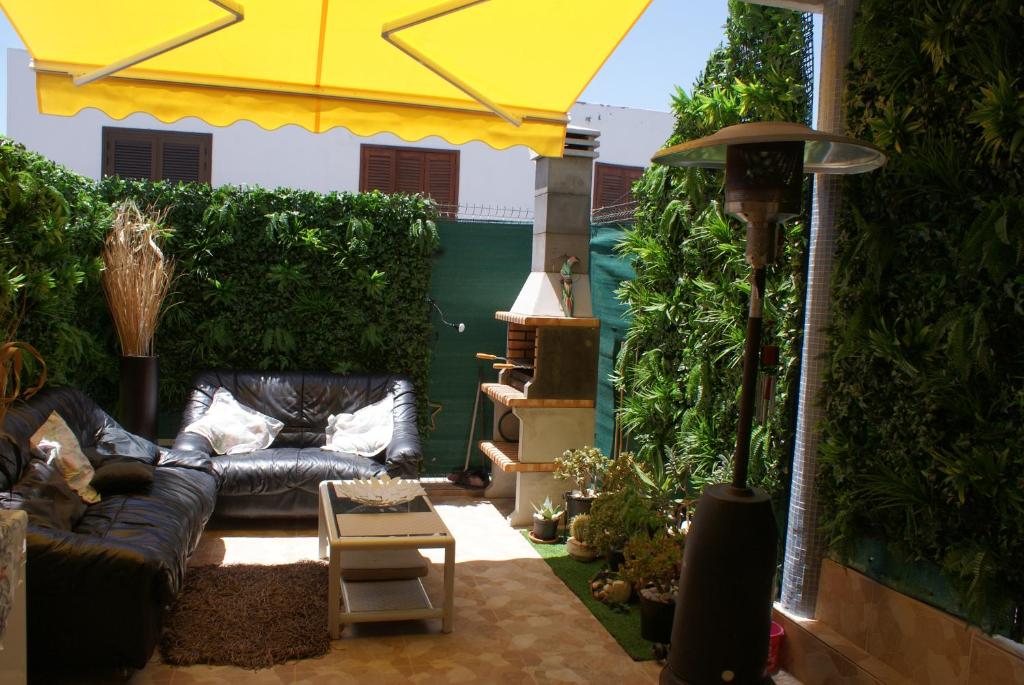 a living room with a couch and a yellow umbrella at Holiday Home Bungamar in Playa de las Americas