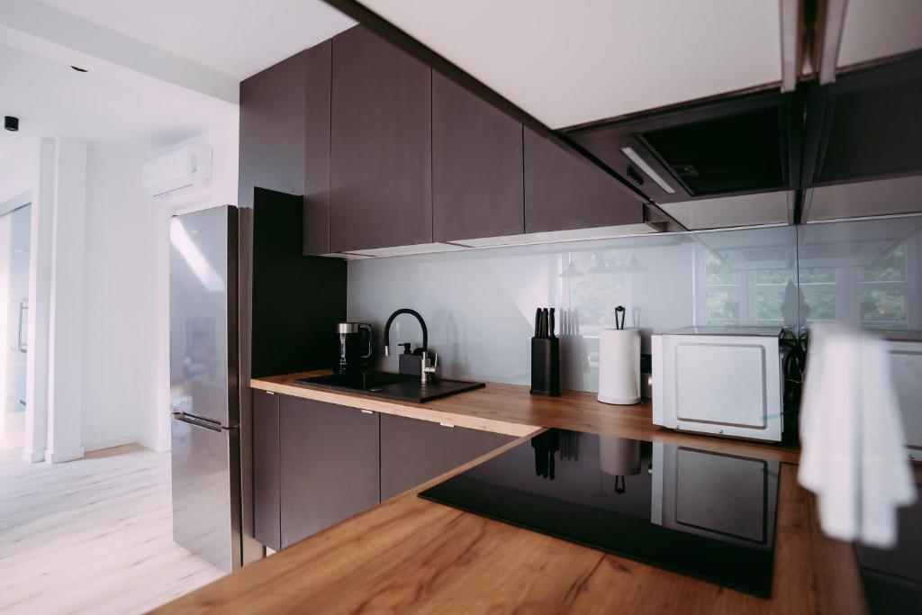 cocina con armarios marrones y encimera de madera en Apartament ,,Loft pod piórem", en Nowy Sącz
