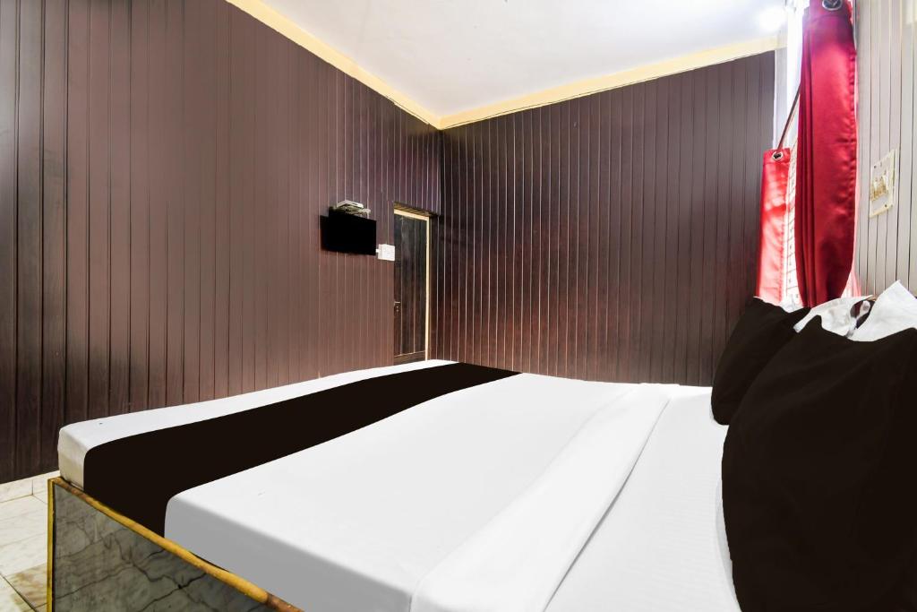 a bedroom with a bed in a wooden wall at Super Hotel Supreet Inn in Raipur