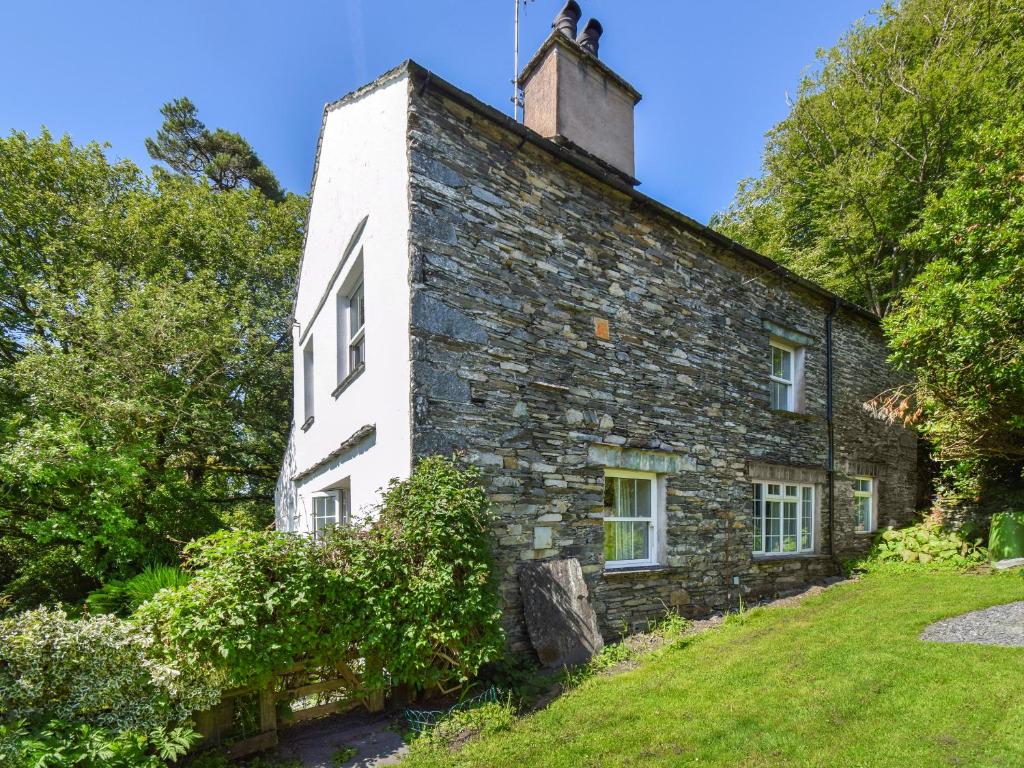 an old stone house with a chimney on top of it at Hollin Bank Barn in Coniston