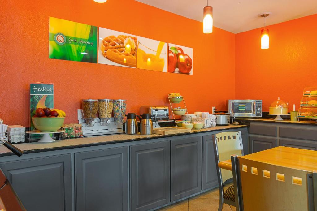 a kitchen with orange walls and a counter with food at Quality Inn Carthage in Carthage