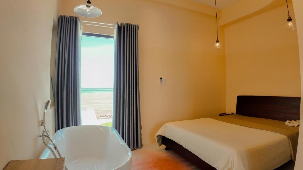 a small bedroom with a bed and a window at Chử - Phan Rang Villa & Tour in Phan Rang