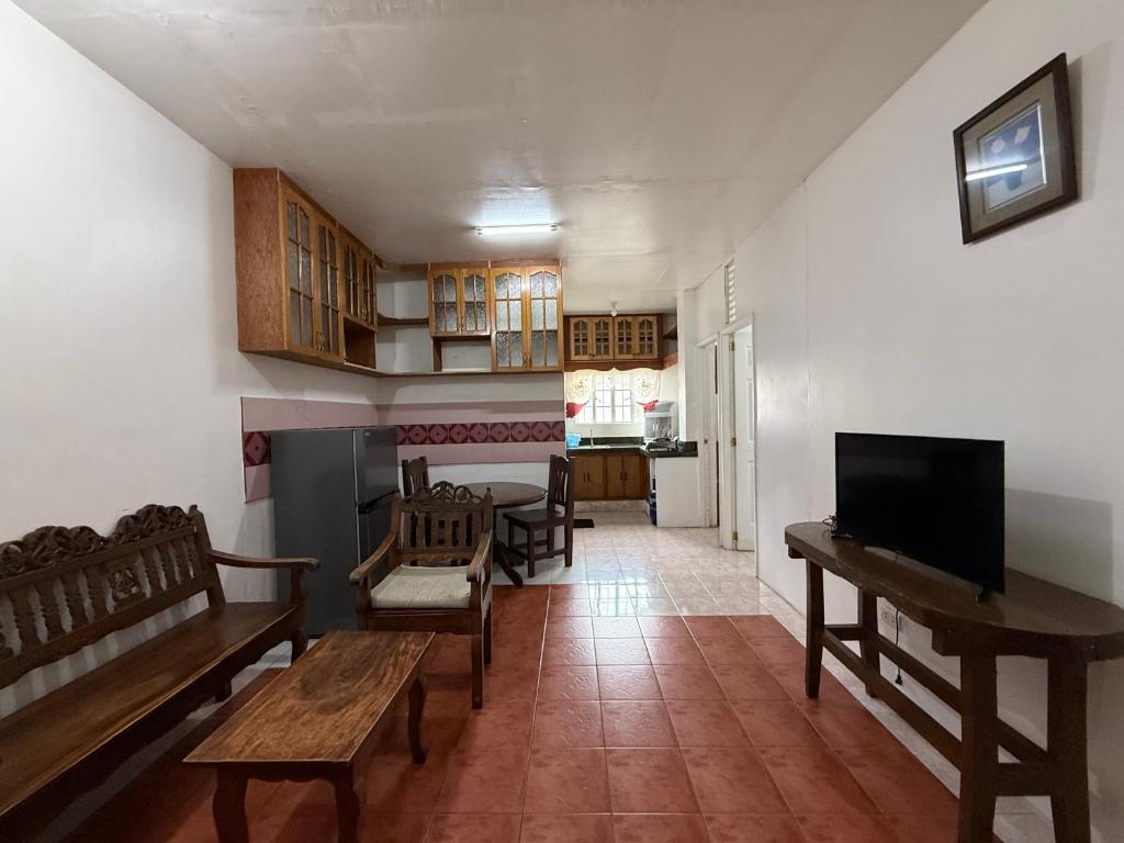 Il comprend un salon doté d'un mobilier en bois et d'une télévision. dans l'établissement Ferionni 2 Apartelle & Suites near BGH, SM and Burnham Park, à Baguio