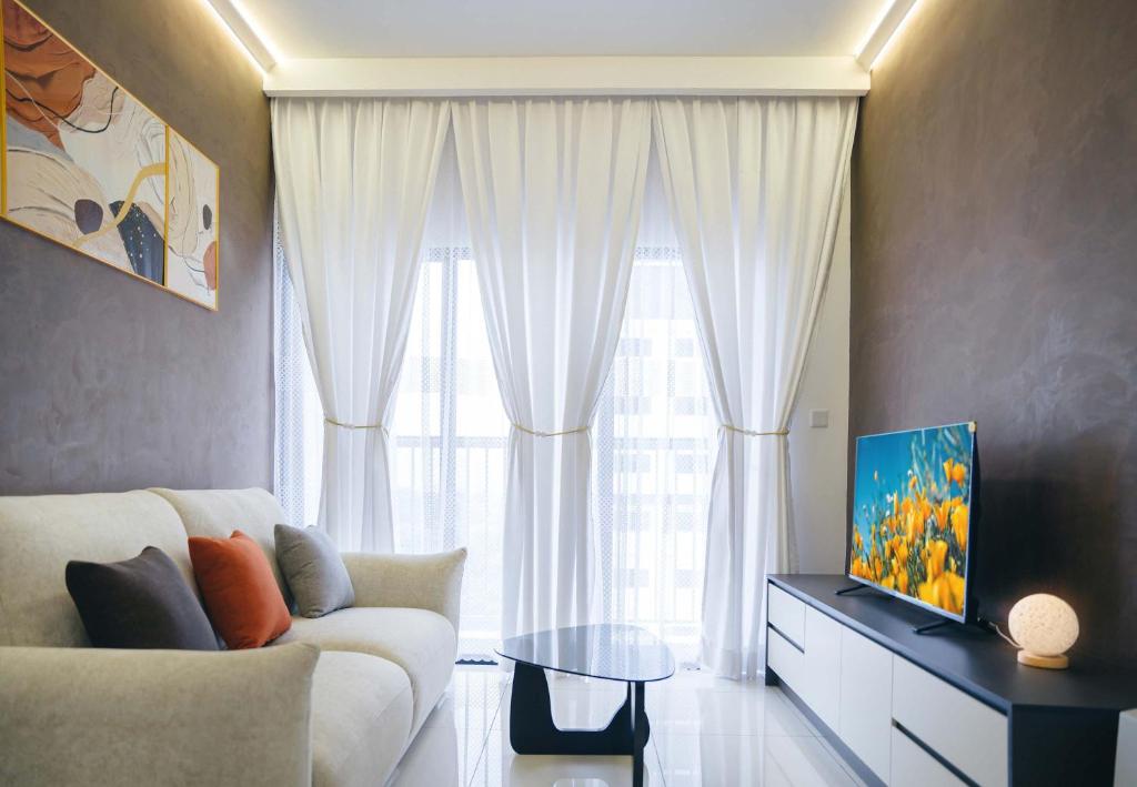 Una sala de estar con un sofá blanco y una ventana grande. en 3BR Traders Park Apartment Cheras KL, en Kampong Bukit Dukong