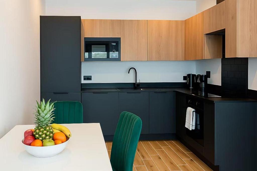Una cocina con una mesa con un bol de fruta encima. en North London 1-Bed Apt Sleeps 3 10 Min to Tube, en Finchley