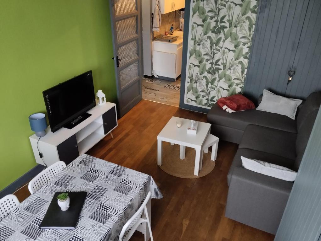 una sala de estar con un sofá y una mesa en Bel appartement a la campagne avec magnifique vue, en Sombernon
