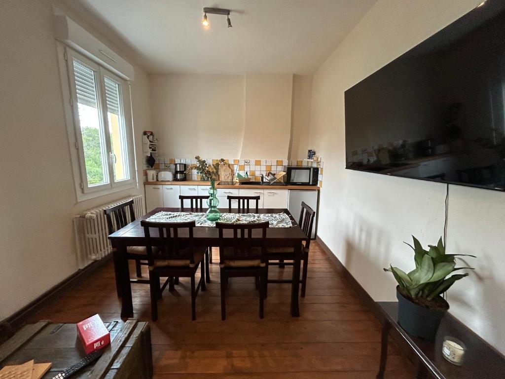 a kitchen with a table and chairs in a room at Logement Salbris sologne in Salbris