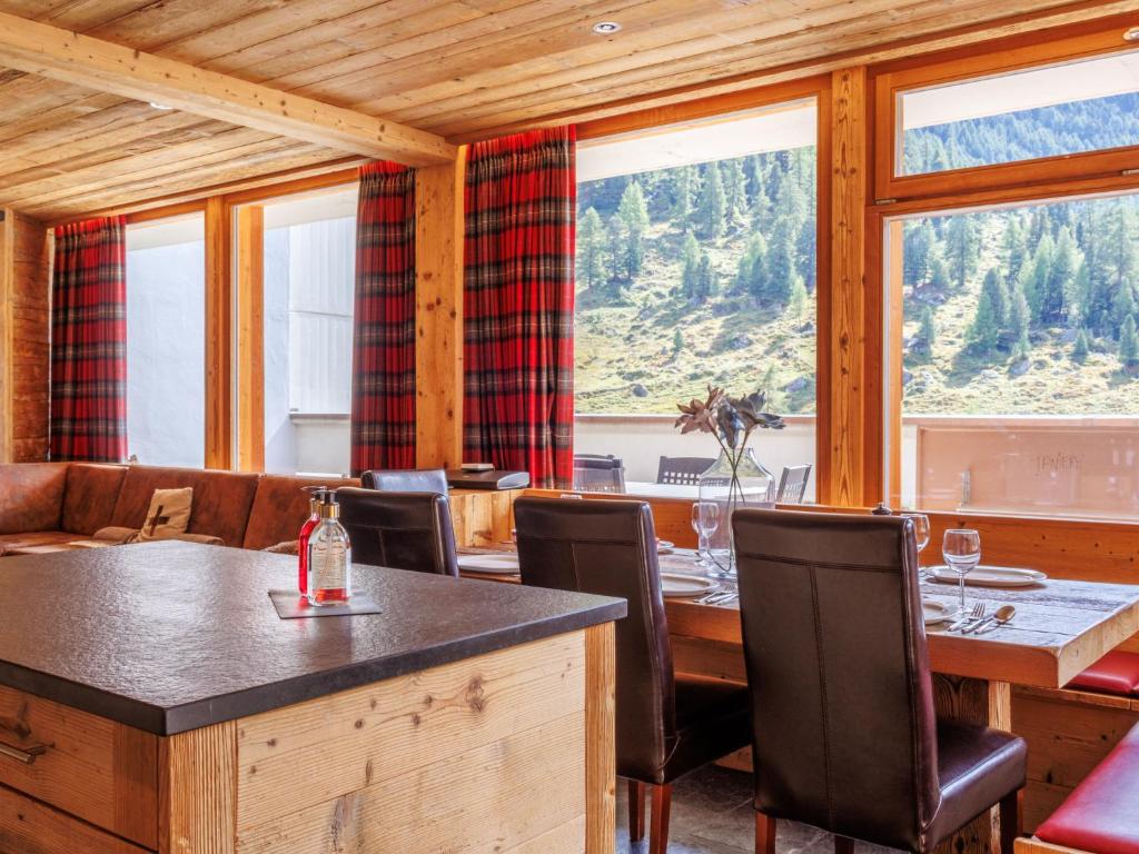 a dining room with a table and chairs and windows at Apartment Rosablanche D Attique by Interhome in Siviez