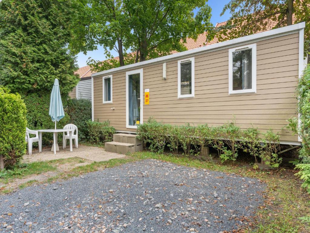 a small house with a table and an umbrella at Holiday Home Florida by Interhome in Prague