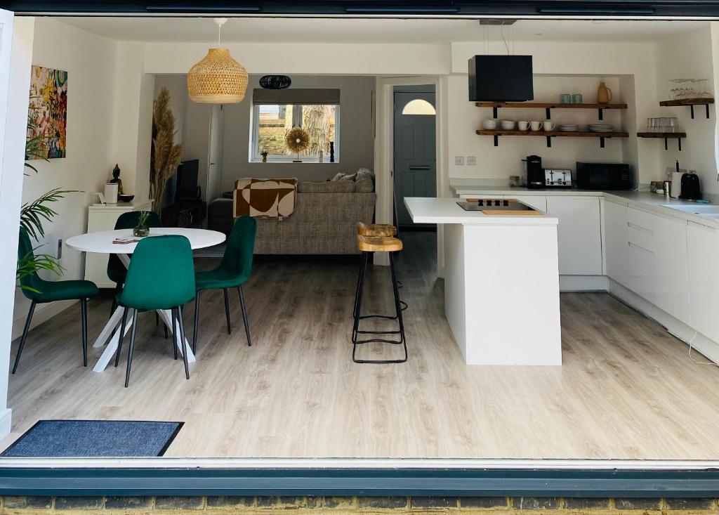 a kitchen and living room with a table and chairs at 2 bedroom cottage in Bromley suitable for 4 people in Bickley