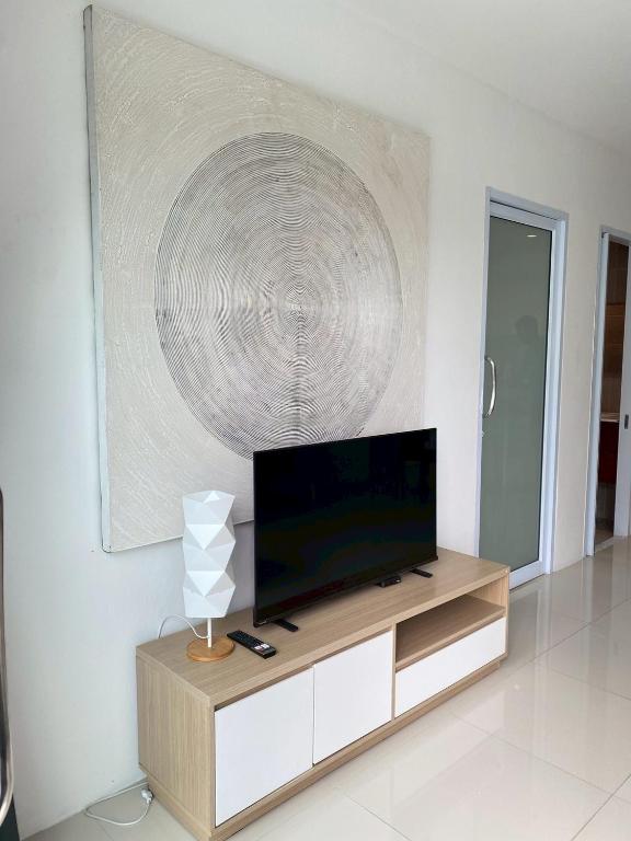 een woonkamer met een flatscreen-tv op een kast bij Serene Hillside Hideaway in Ban Ko Khwan