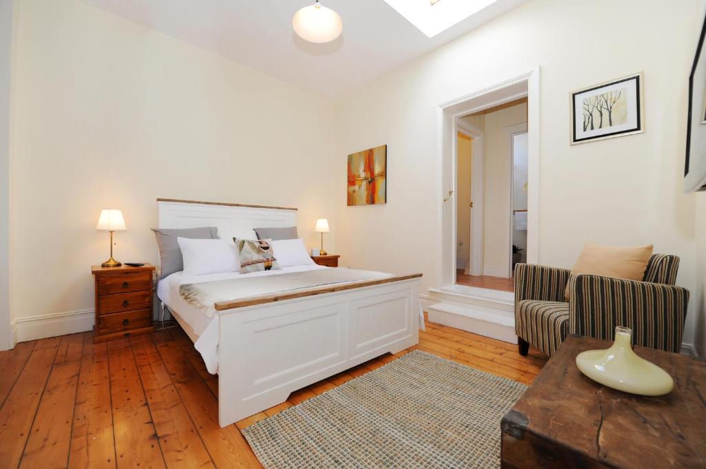 a bedroom with a large white bed and a chair at Spencer Suites Albany in Albany