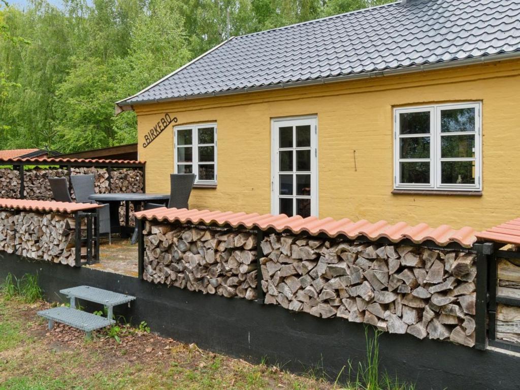 a house with a wall of fire wood at Holiday Home Andri - 1-5km from the sea by Interhome in Rønne
