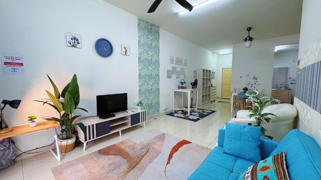 a living room with a blue couch and a tv at KAJANG Sri Ixora Kajang Spacious Home Fully AirCon in Kajang
