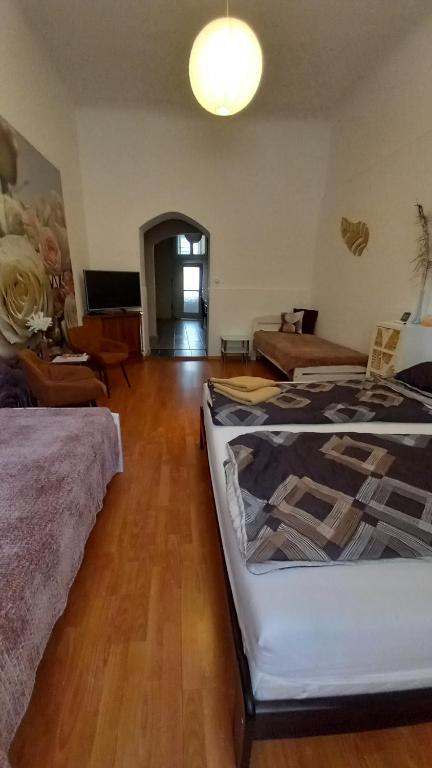 a room with two beds and a living room at Szép-Lak Makó in Makó