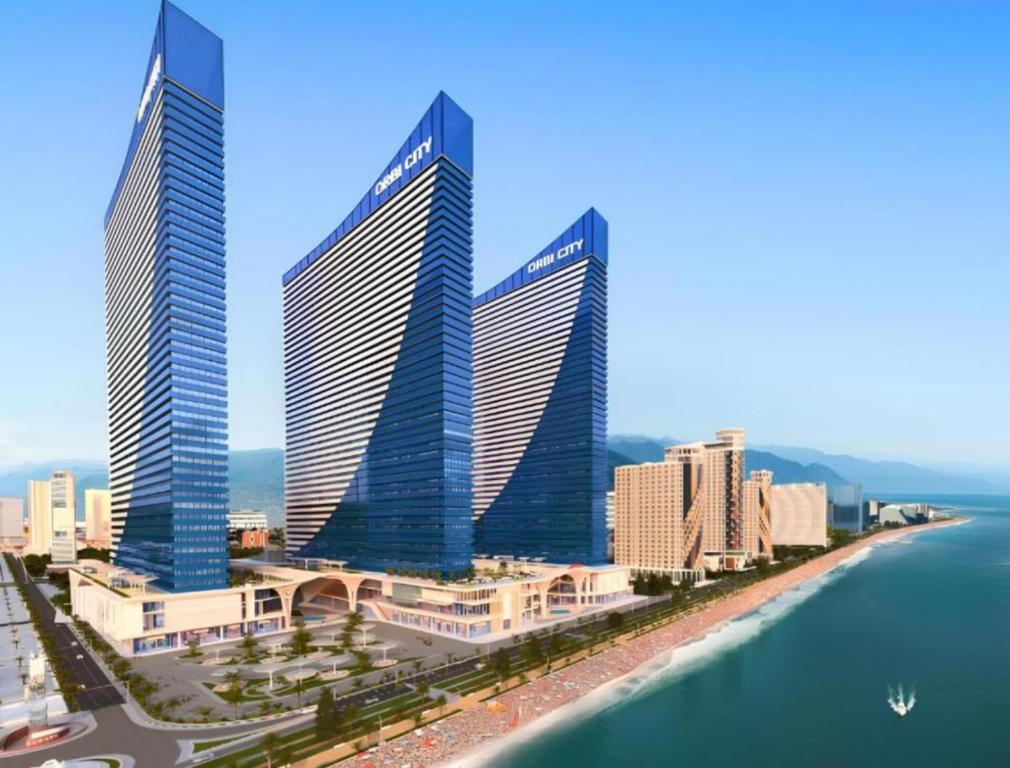 バトゥミにあるORBI CITY - Batumi View Apartmentの水辺の三棟の高層ビル