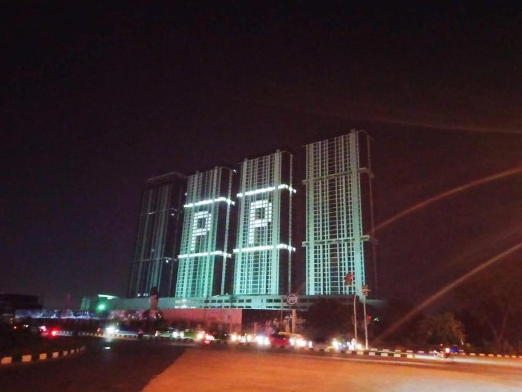 a building lit up in green and white at night at Aldrich axelle pollux in Bagam