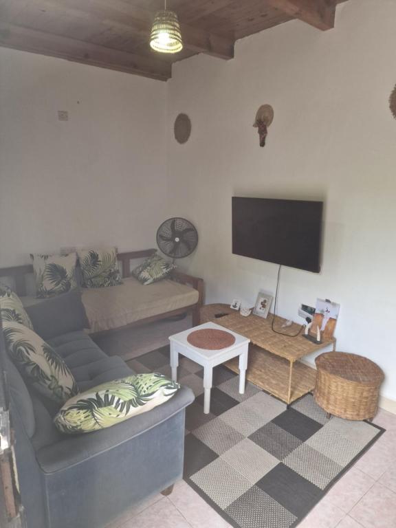 a living room with a couch and a flat screen tv at Diani Beach Relax in Diani Beach