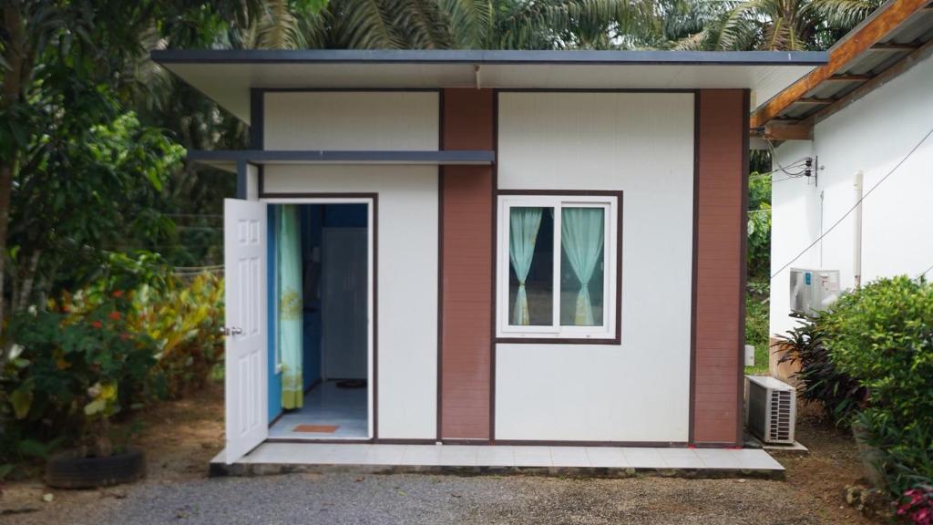 a small house with a door and a window at Baan Gamnan Resort Krabi in Ban Khao Ngam