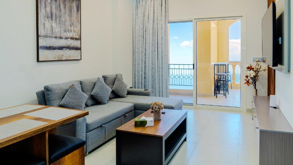 a living room with a couch and a table at Breathtaking Sea View Retreat by Hala Homes in Ras al Khaimah