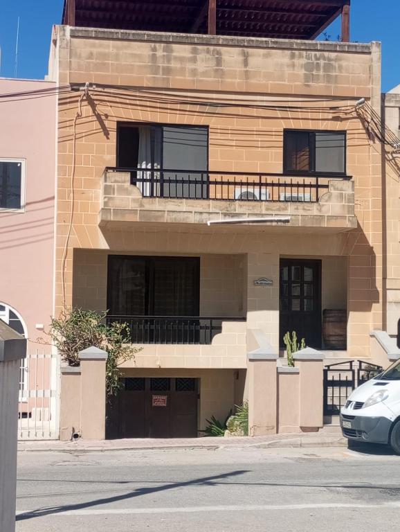 an apartment building with a balcony and a car parked in front at Mediterranean Villa in St. Paul's Bay