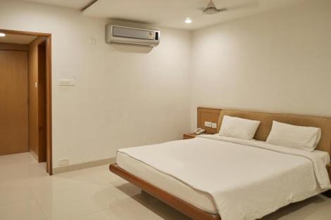 a bedroom with a large white bed in a room at Hotel Ashwini Lodge in Mysore