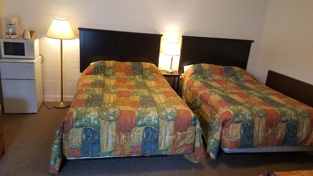Postel nebo postele na pokoji v ubytování Centennial Motel