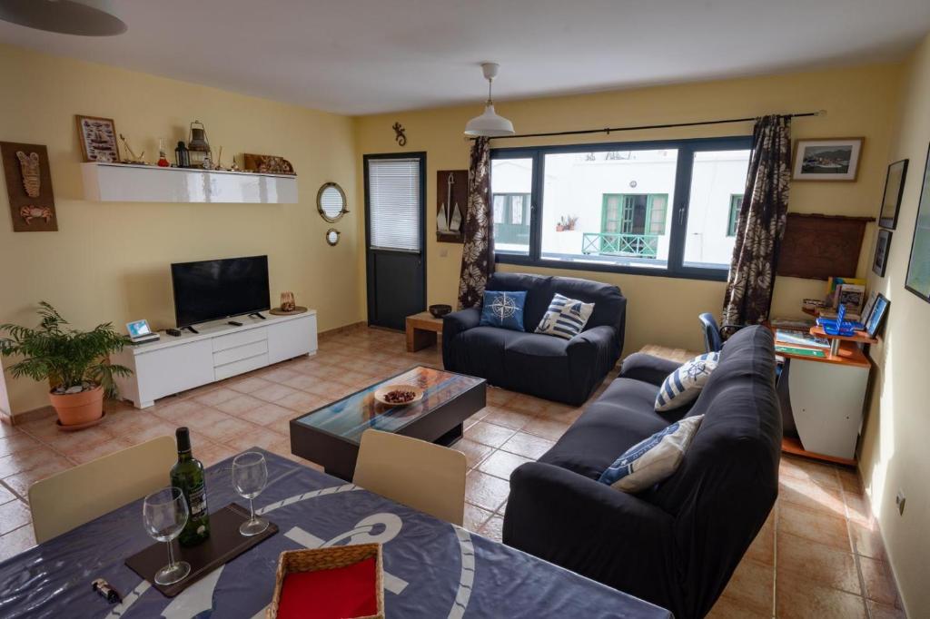 un salon avec un canapé et une télévision dans l'établissement apartamento anzuelo, à Famara