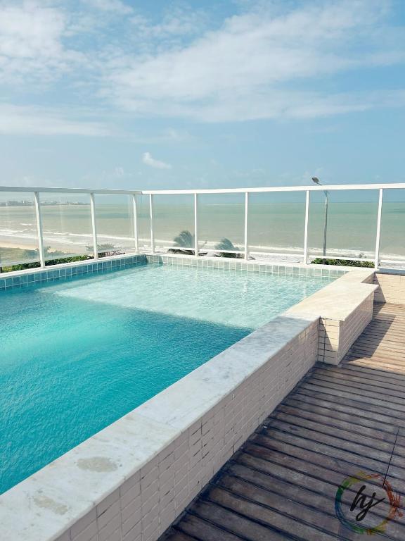 a swimming pool with the ocean in the background at Paradise Flat 412 in Nossa Senhora do Livramento