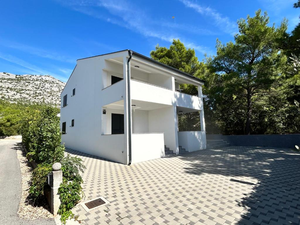 a white house with a lot of windows at Apartmani Kim in Starigrad