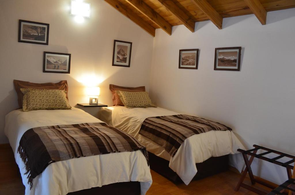 1 dormitorio con 2 camas y lámpara en El Chalten Aparts en El Chaltén