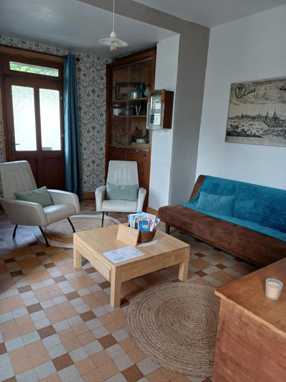 a living room with a couch and a coffee table at L'Epicerie Maison années 30 in Caen