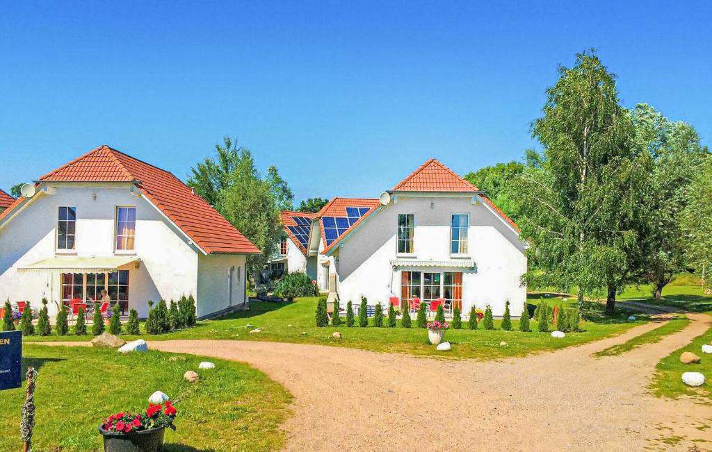 two white houses with red roofs on a dirt road at Ferienhaus Verchen in Verchen