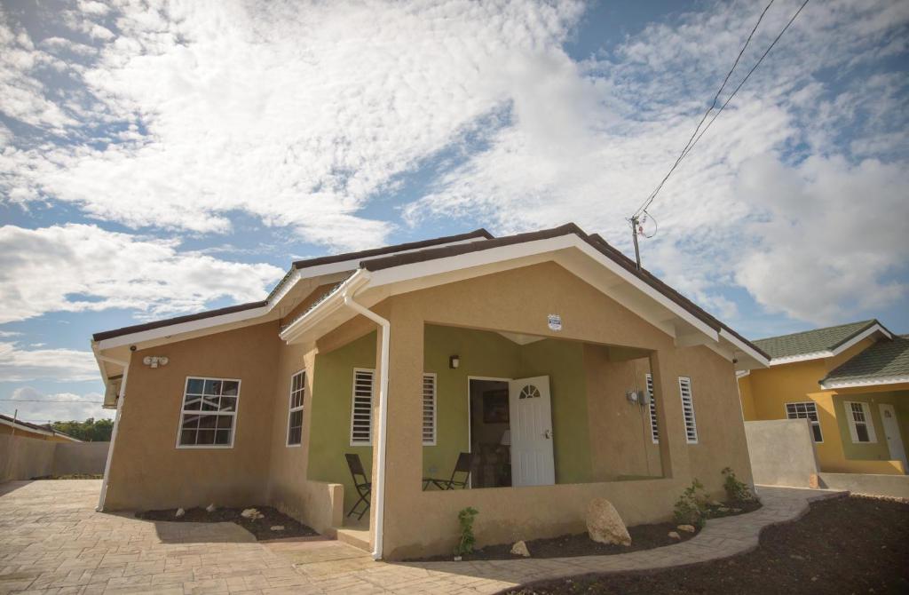 uma pequena casa com uma porta branca em frente em Villa Oasis Drax Hall em Ocho Rios