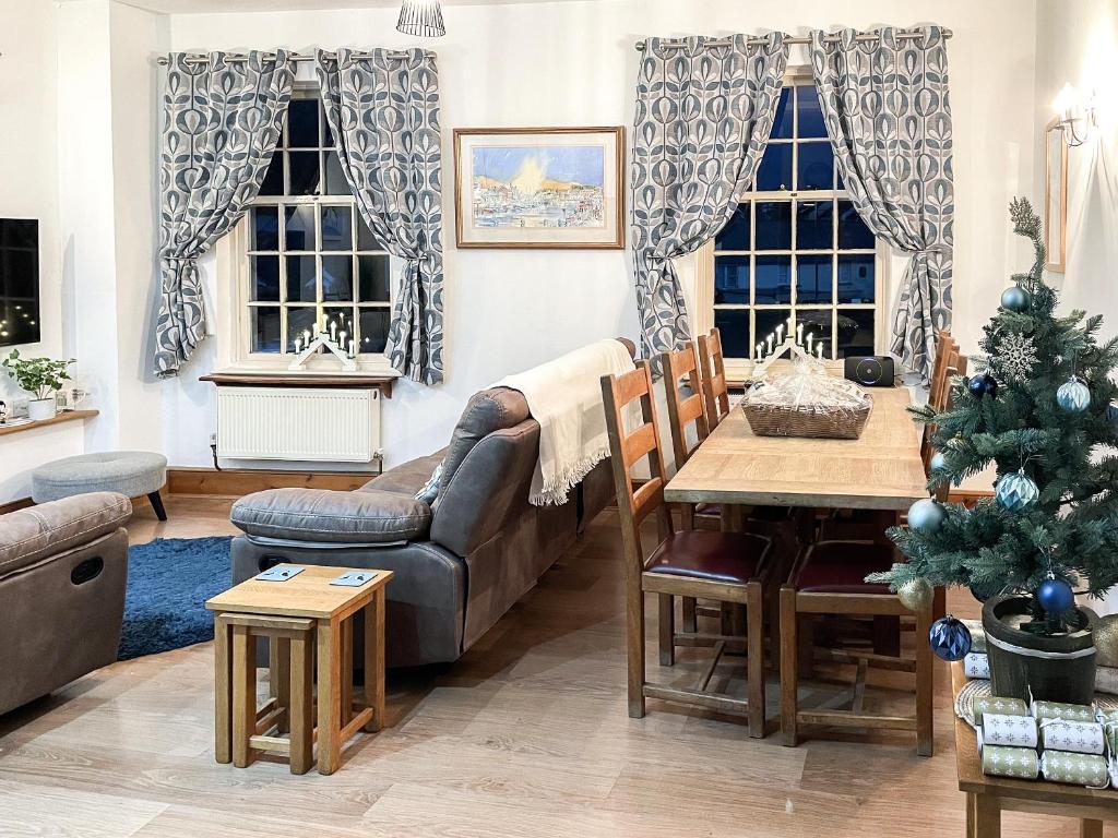 Una sala de estar con un árbol de Navidad y un sofá. en The Boathouse, en Appledore