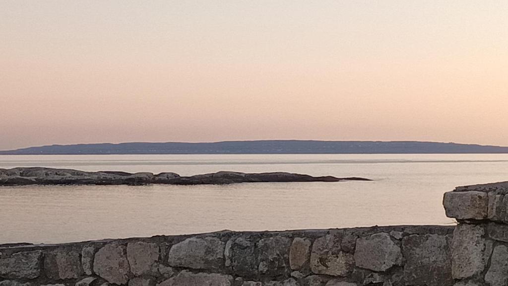 a large body of water with a stone wall at Atlantic beach house in Dog Island