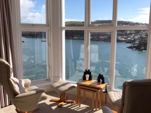 ein Wohnzimmer mit einem großen Fenster mit Blick auf das Wasser in der Unterkunft St Catherines Court No 7 in Fowey