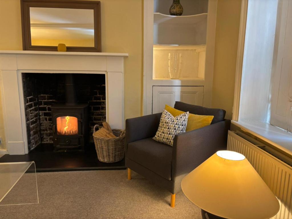 a living room with a couch and a fireplace at Winter Escape in beautiful English Countryside - Free Private Parking for up to 4 cars, EV Charging Point, Log Burners, Wood Burning Stoves, Tennis Courts, Large Garden area & Lots of nearby things to do! in Goodnestone