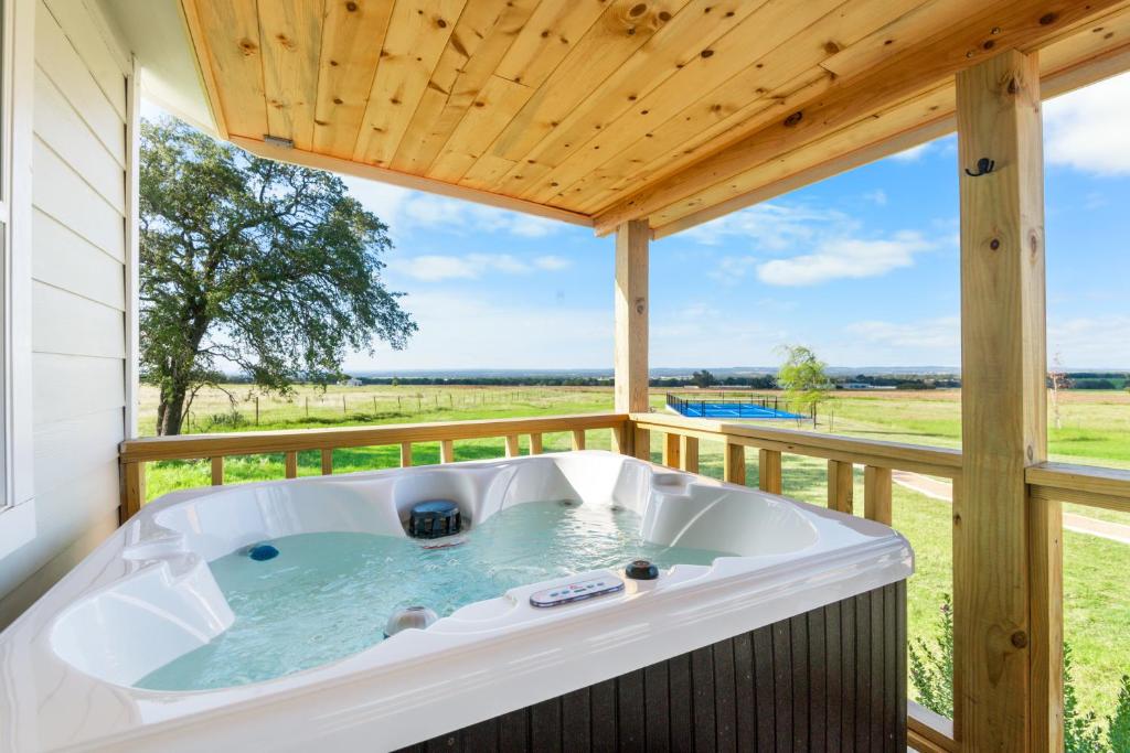 a jacuzzi tub on a porch with a wooden ceiling at Laurel Court Cottages- A Pickleball Getaway in Fredericksburg