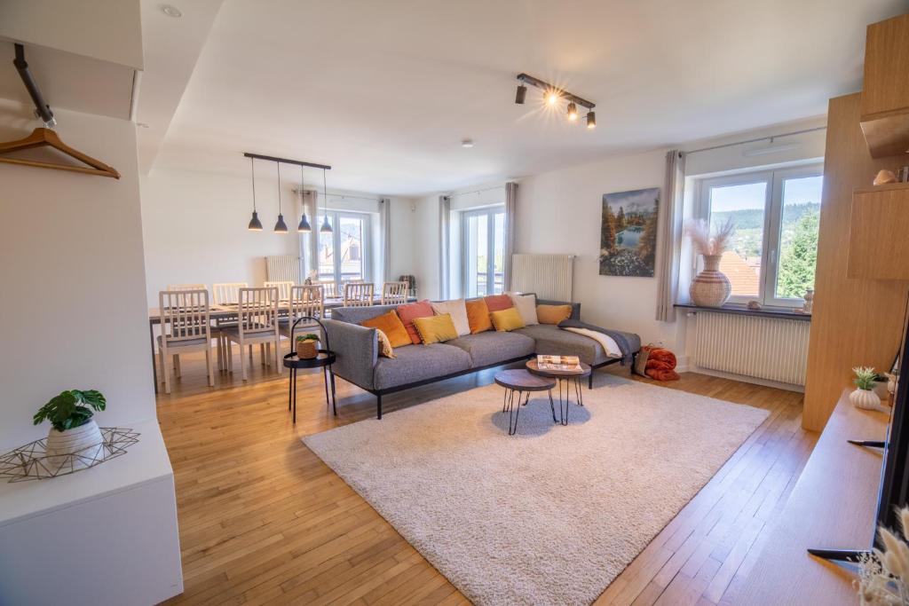a living room with a couch and a table at Appartement 3ch rénové en 2023 avec sauna in Gérardmer