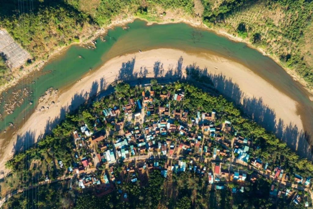 an aerial view of a village on a river at Coffee Homestay A Vũ in Kon Cho Dri
