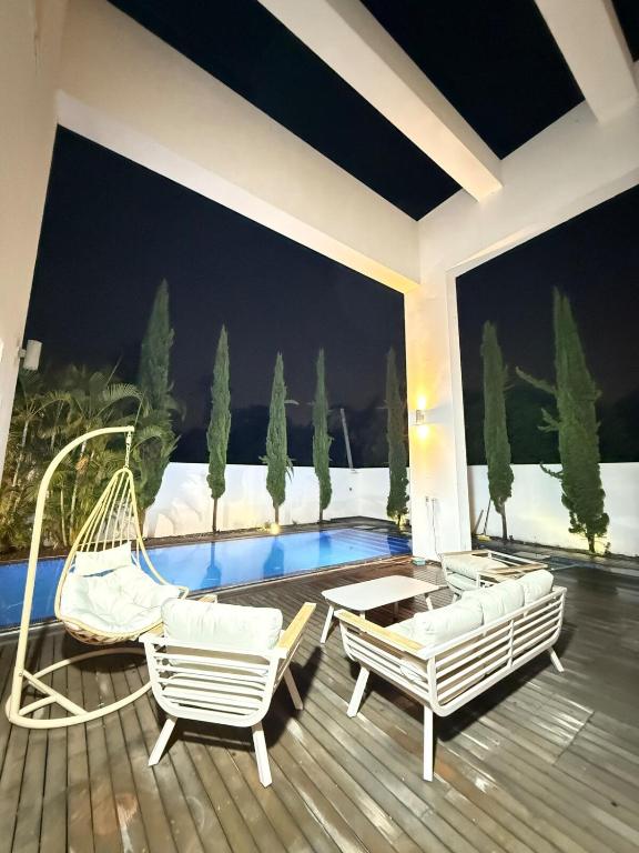 a patio with two chairs and a swimming pool at Villa with a pool in Ra'anana in Ra‘ananna