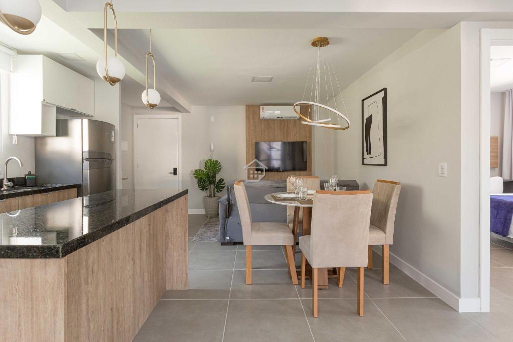 a kitchen and dining room with a table and chairs at Edifício Link by Rezervo in Santo Antônio