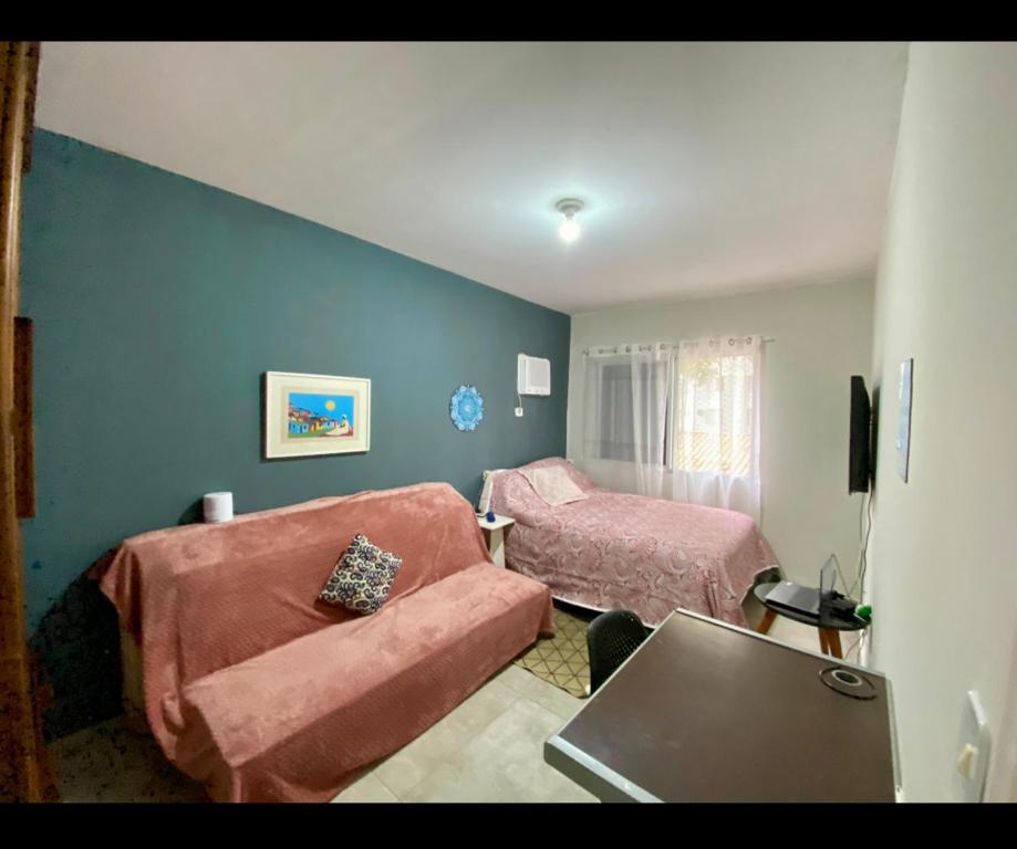 una sala de estar con un sofá y una cama en Apto Natal e Réveillon, en Ubatuba